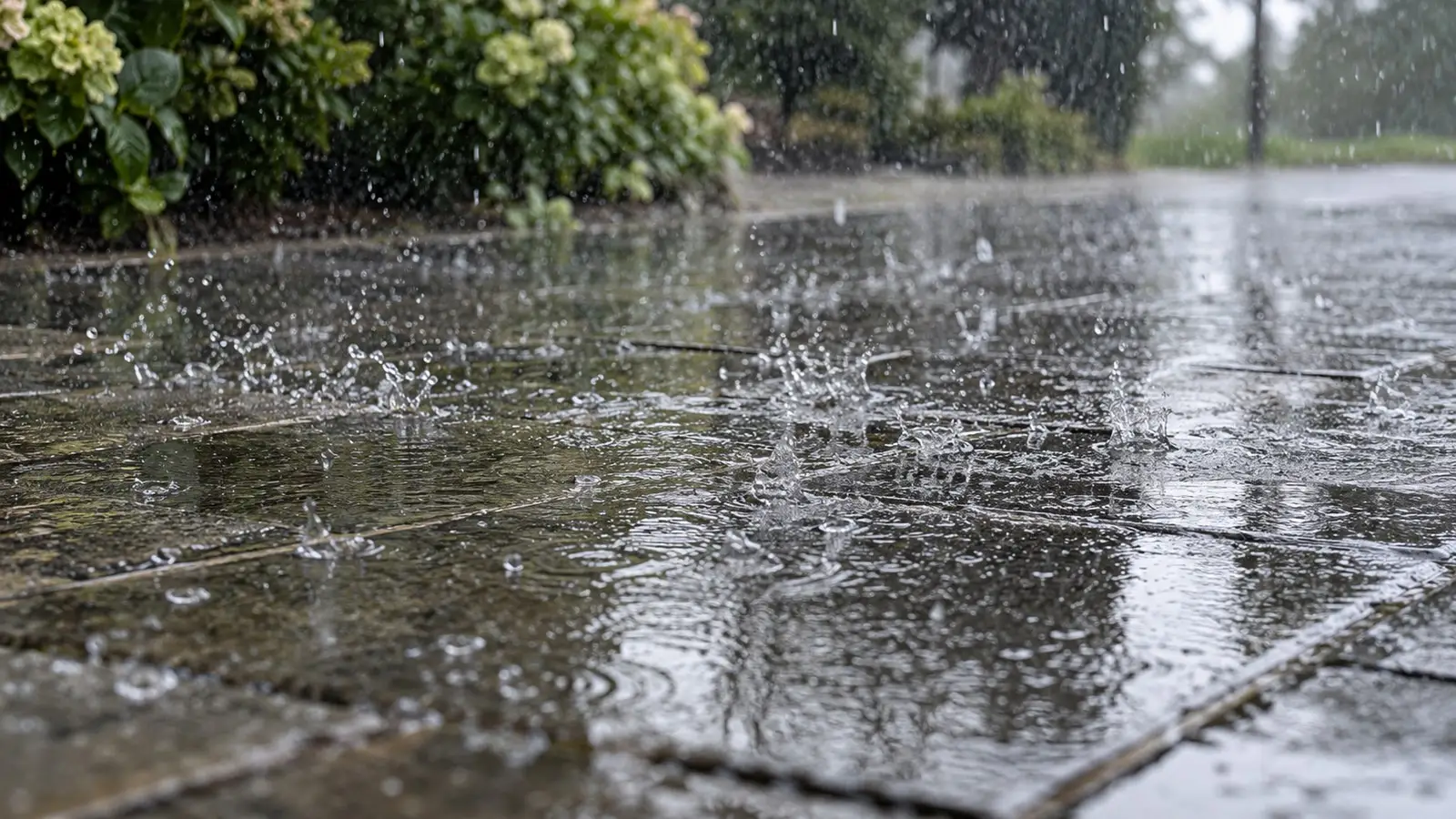 Regen auf Pflastersteinen. Neutrale Alltagskulisse ohne behaupteten Aufnahmeort.